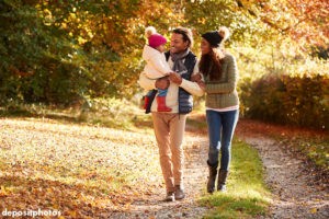 Couple walking with their toddler in a fall landscape