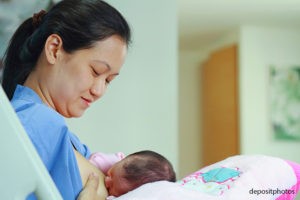 The mother is breastfeeding her baby in a hospital