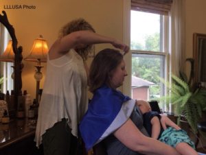 Mother nursing her toddler while getting her hair done