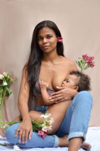 Mother nursing her toddler holding flowers