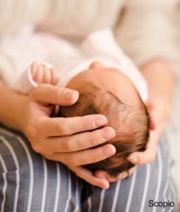 Mother cradling newborn on her knees